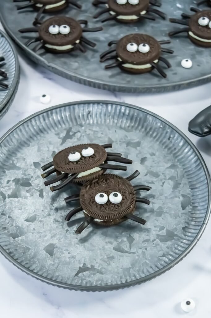 Oreo Spider Cookies with candy eyes and licorice legs served on a round metal tray, a fun no-bake Halloween party snack or classroom treat for kids.