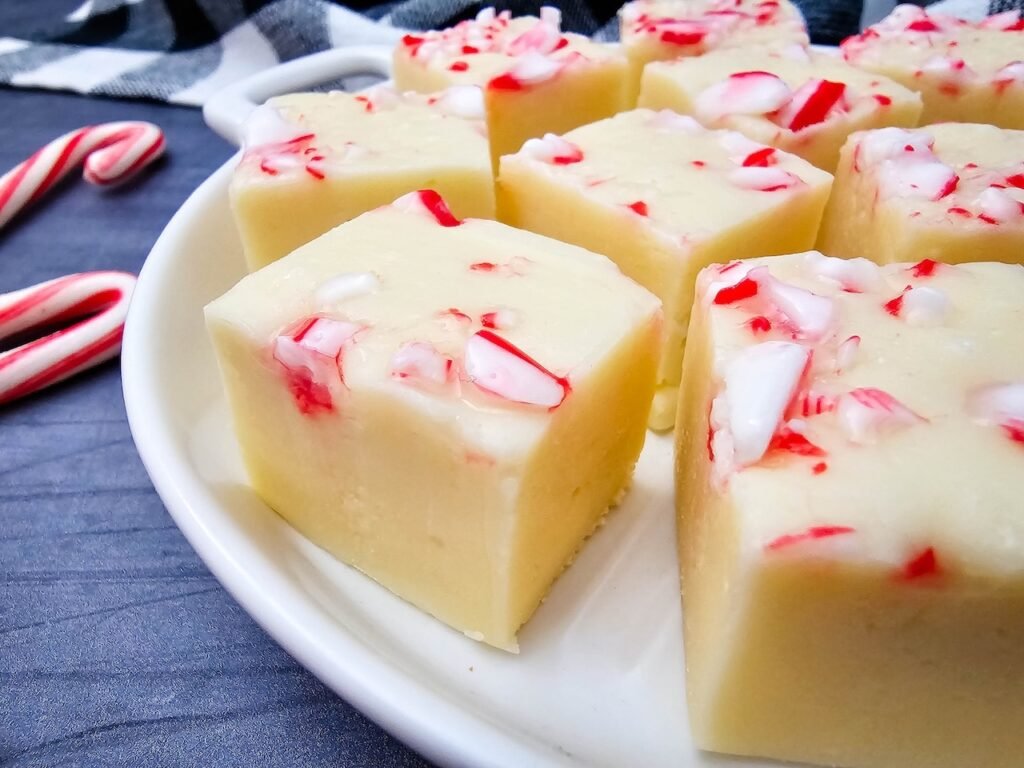 Close-up of candy cane fudge showing smooth texture and chunks of peppermint on top.