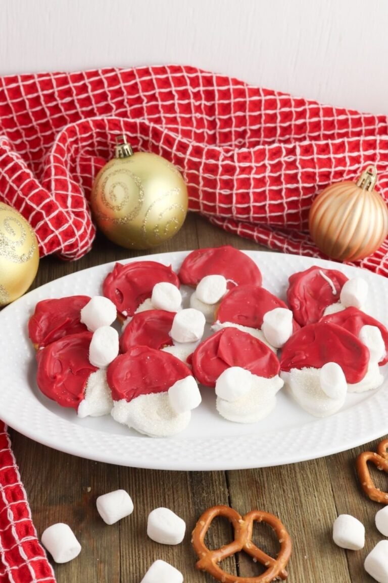 Plate of Christmas pretzel Santa hats made with red candy melts and marshmallows, festive holiday treat