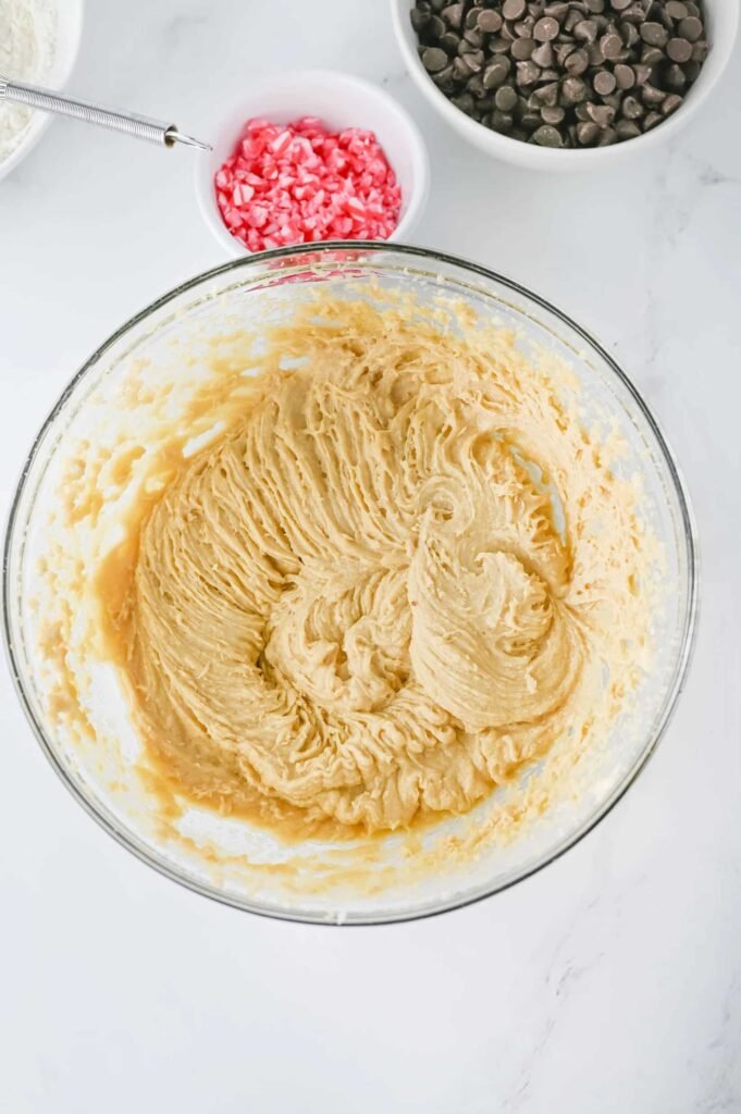 Smooth dough mixed with eggs and vanilla in a glass bowl.