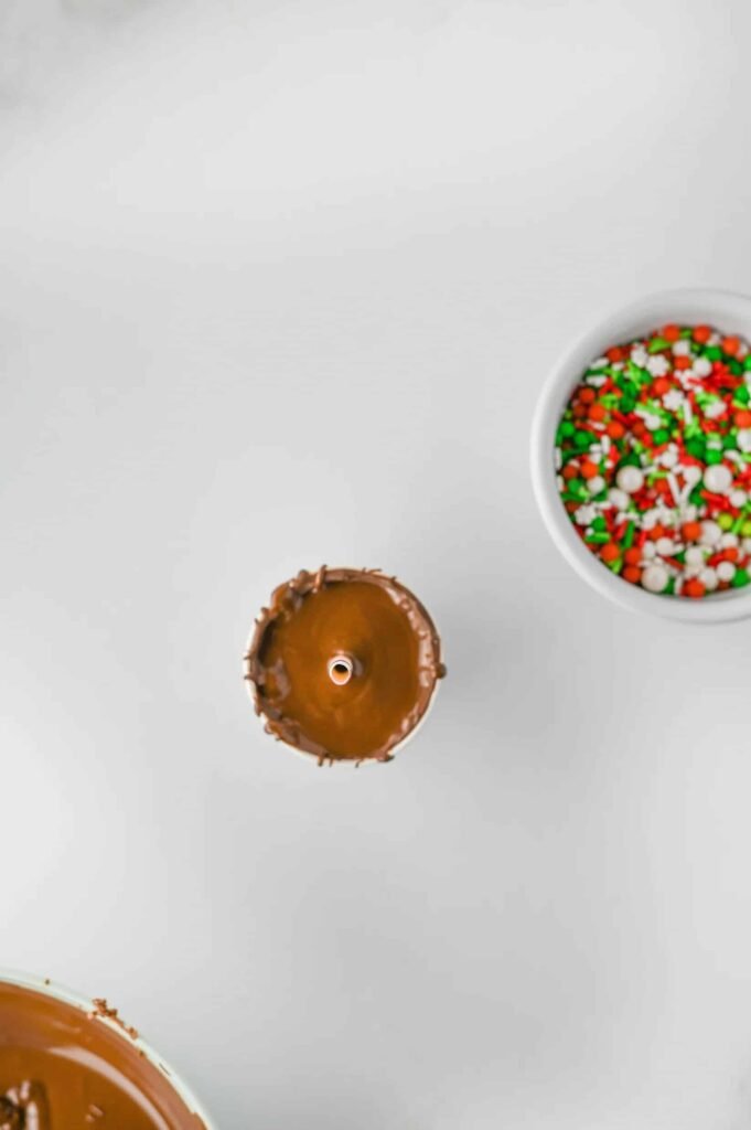 Step 5: Seal the cocoa mix with a smooth layer of melted chocolate before adding marshmallows and sprinkles.