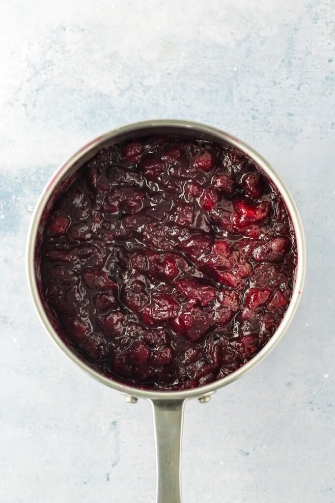 Step 3 — cranberries simmering and bursting in a saucepan until thick and glossy.
