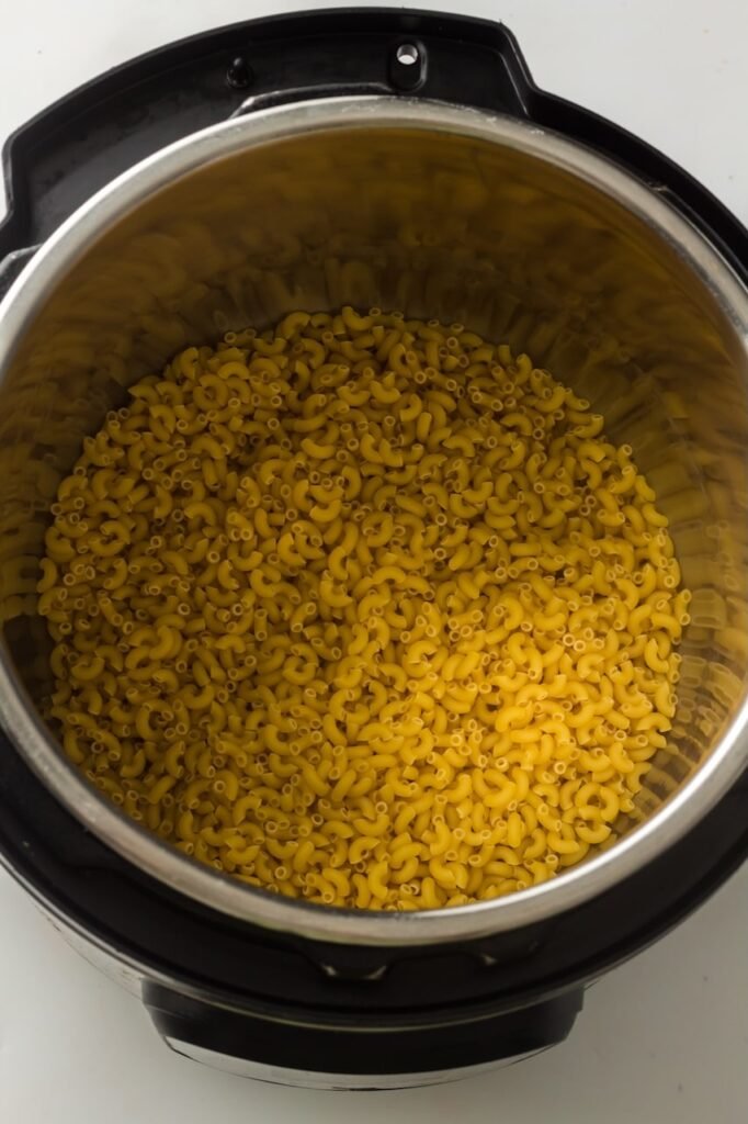Uncooked elbow macaroni inside a Pot before adding water and butter for homemade mac and cheese.