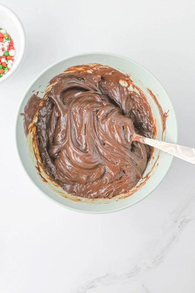 Bowl of melted semi-sweet mixture being stirred for the first layer.