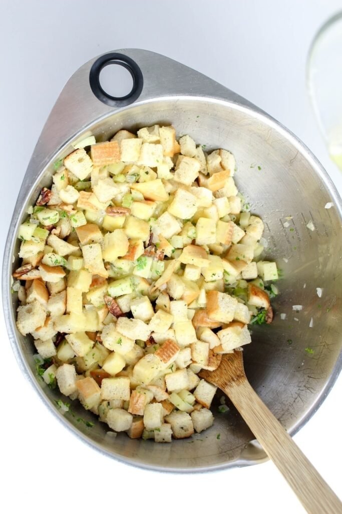 Mixing ingredients with broth and eggs in a large bowl before baking.