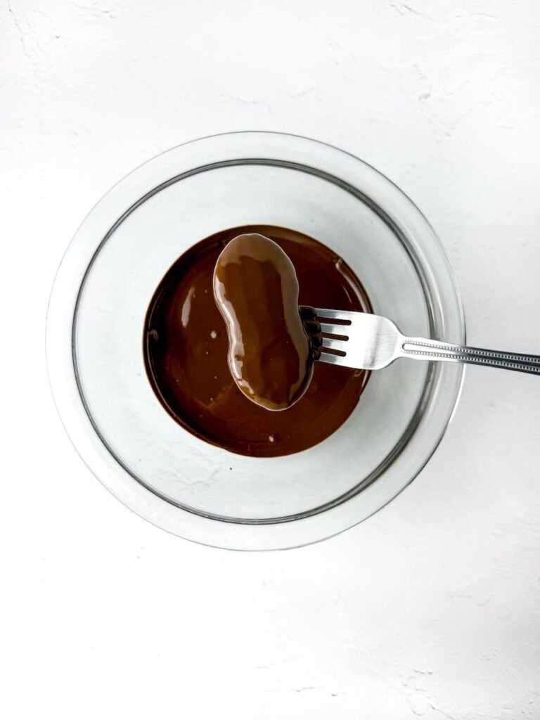Step 2: Lift each cookie with a fork and let the extra drip off before setting it on parchment.