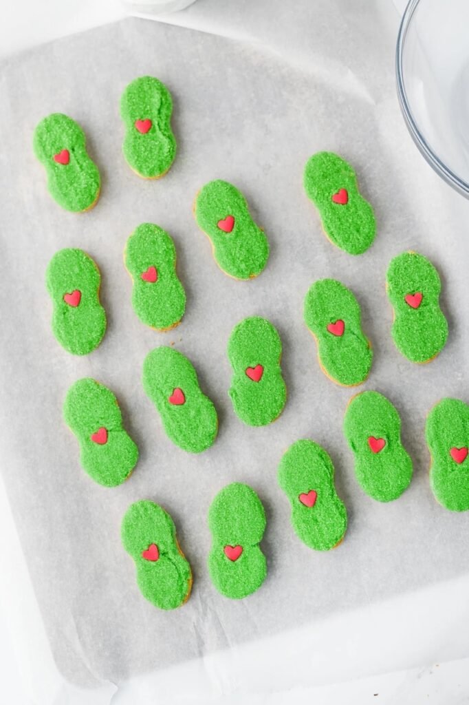 Finished dessert with green sanding sugar and red heart sprinkles arranged on parchment paper.