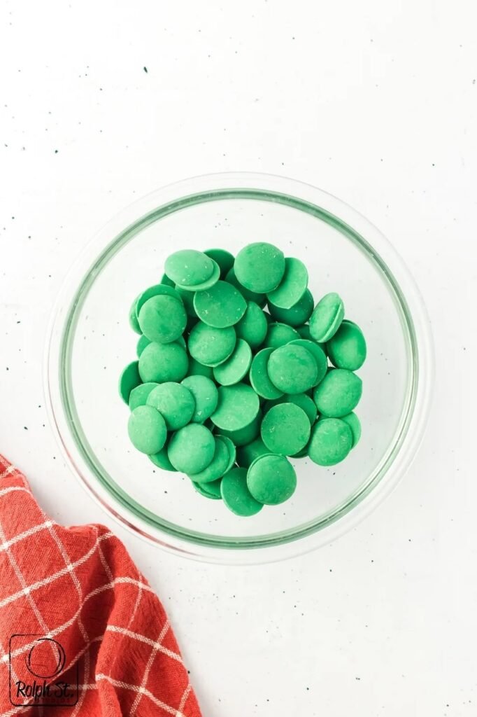 Green candy melts in a glass bowl ready to be melted for dessert