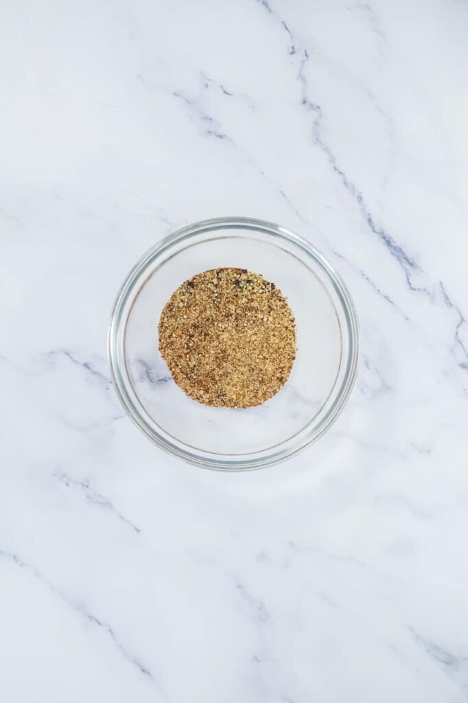 A small glass bowl filled with a homemade seasoning mix.