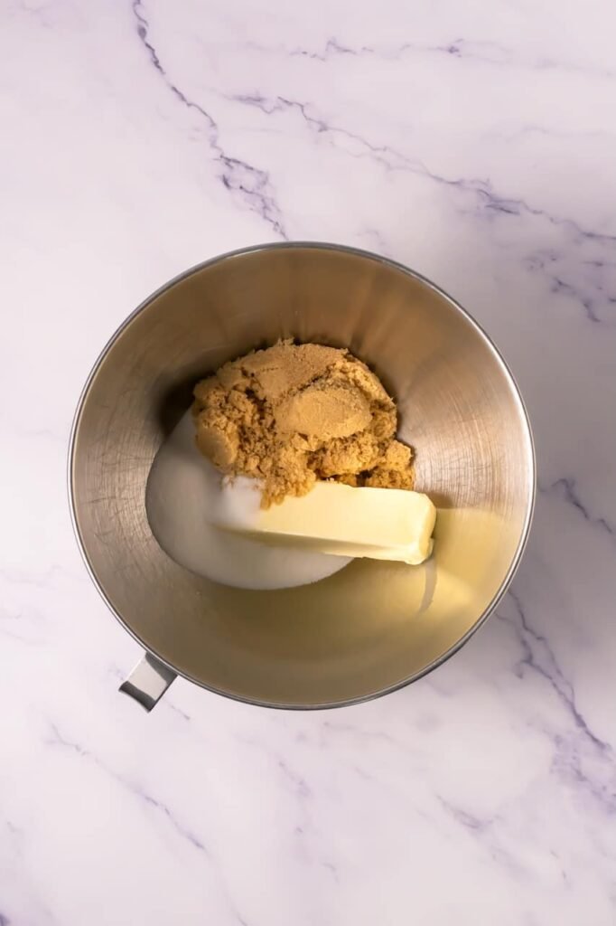 Butter, brown sugar, and granulated sugar in a stand mixer bowl ready to be creamed together for chocolate mallow cupcake cookie dough.