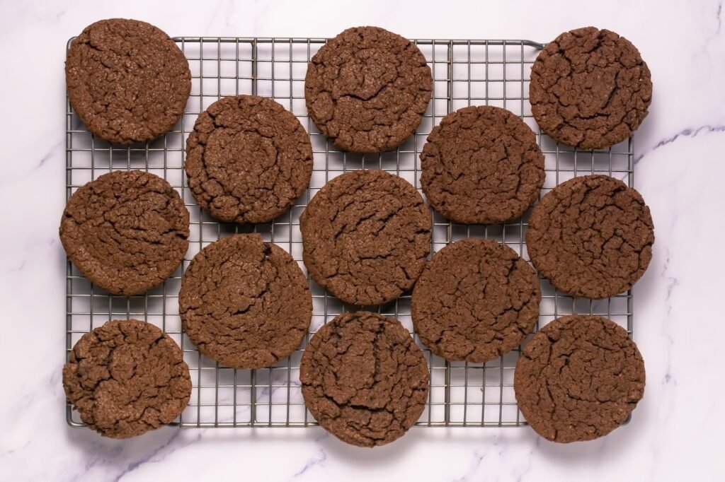 Overhead view of freshly baked  cookies cooling on a wire rack, showing thick, soft texture.