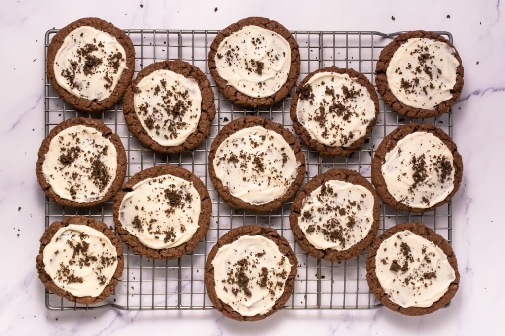 Overhead view of dessert with smooth frosting and sprinkled with Oreo crumbs, arranged on a cooling rack.
