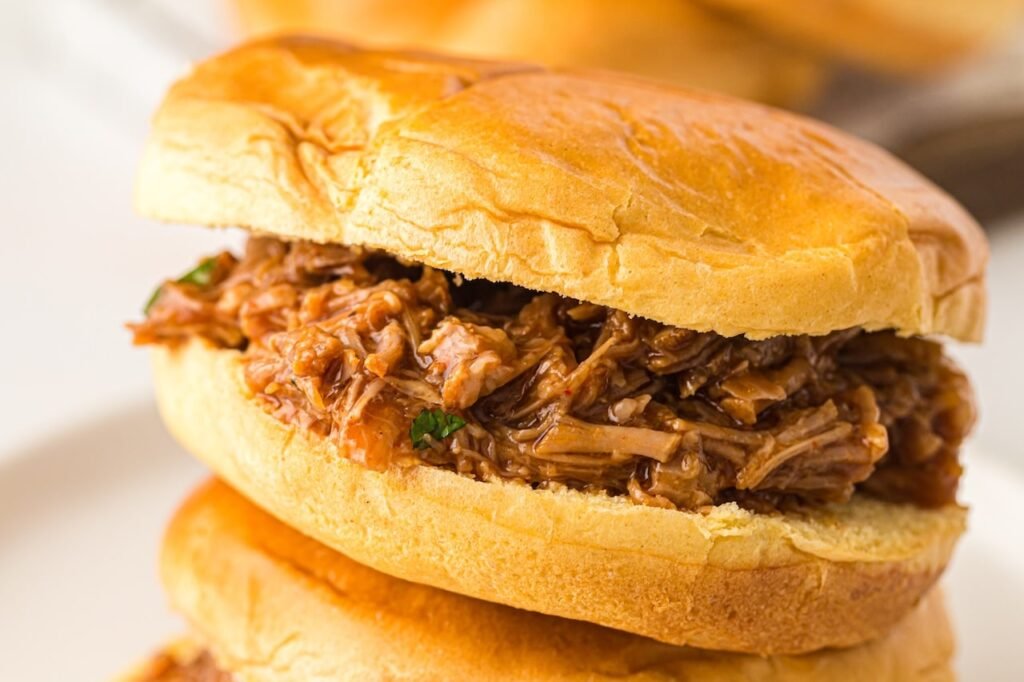 Close-up of a BBQ pulled pork sandwich made with tender shredded Instant Pot pulled pork on a soft sandwich bun.
