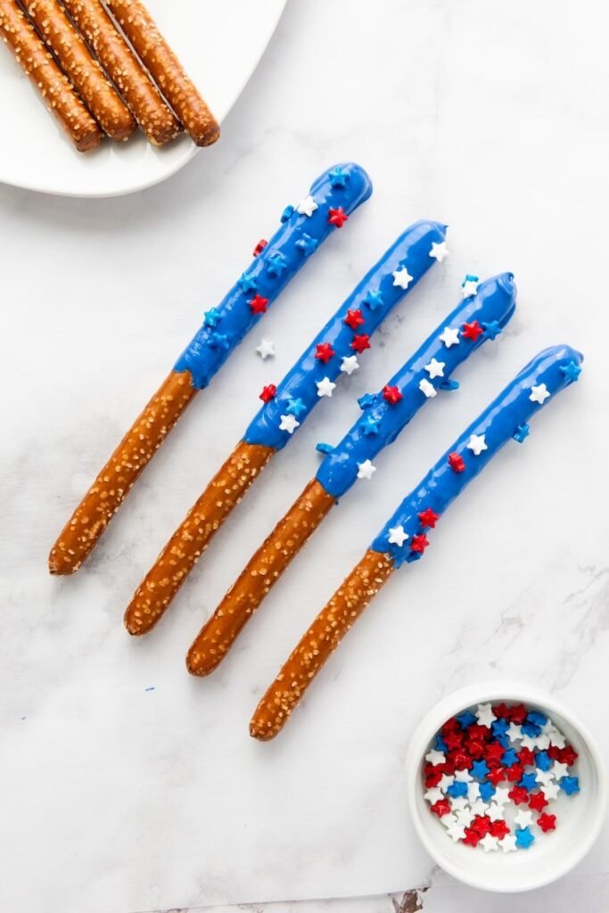 dessert dipped in blue candy coating with red and white sprinkles, partially visible in a distorted image.