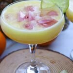 Pineapple margarita mocktail served over ice in a glass with a lime slice garnish, showing a refreshing tropical drink.